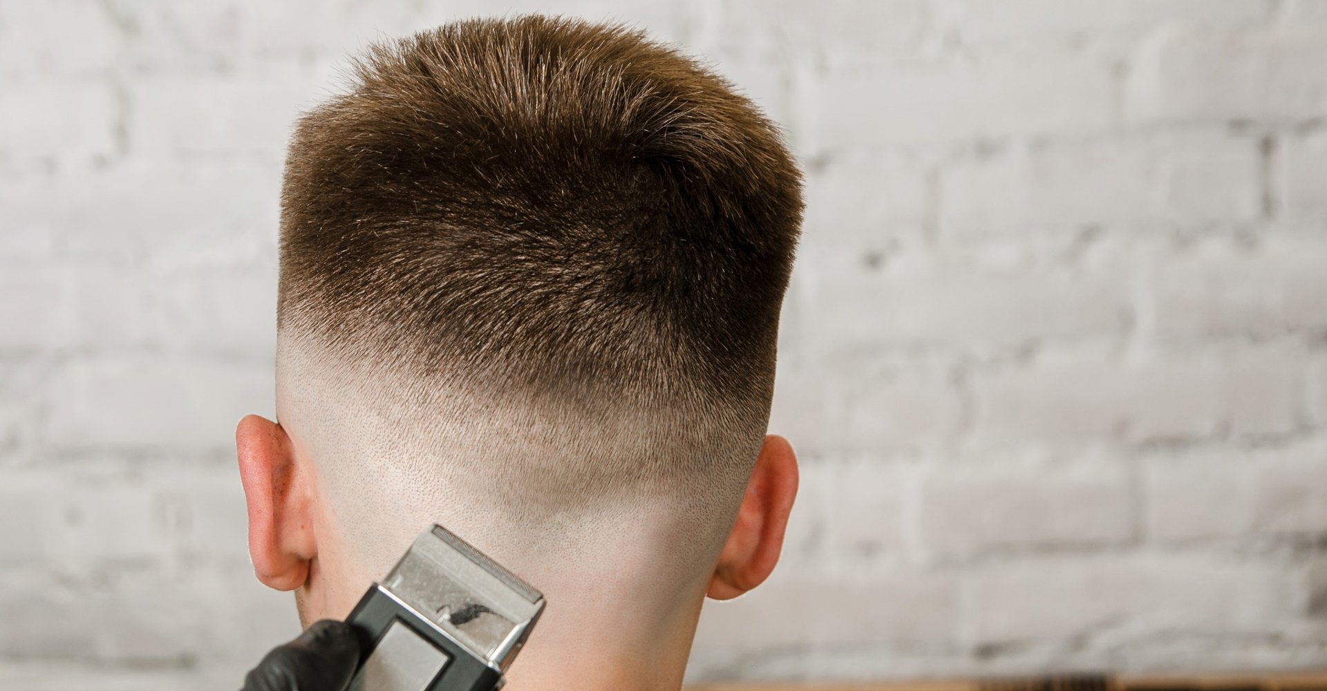 Jovem recebe um corte high fade estiloso em barbearia moderna